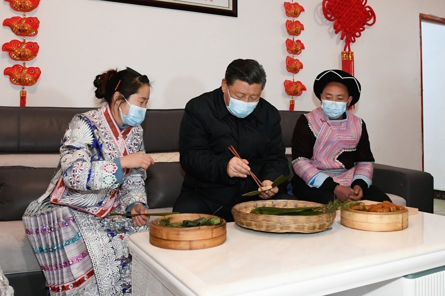 2021年2月3日下午，習(xí)近平在貴州畢節(jié)市黔西縣新仁苗族鄉(xiāng)化屋村苗族村民趙玉學(xué)家，同一家人邊聊家常邊制作當(dāng)?shù)貍鹘y(tǒng)節(jié)日食品黃粑。新華社記者 李學(xué)仁 攝